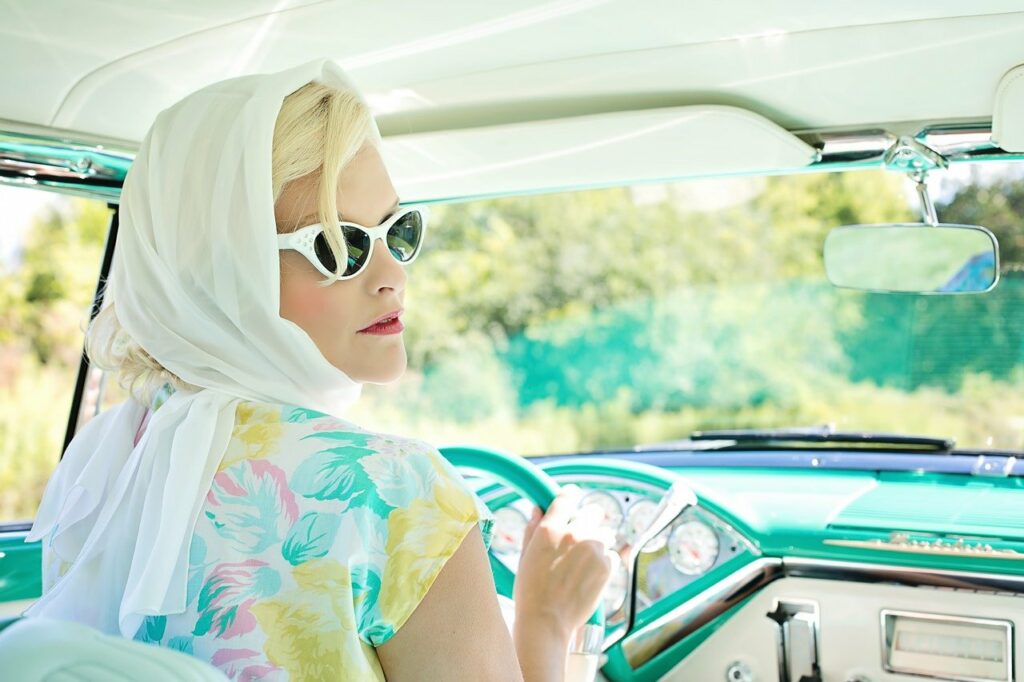 Lohnt sich ein Auto noch Vintage Auto Frau am Steuer Sonnenbrille