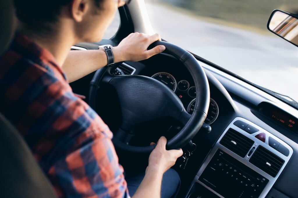 Mann unterwegs im Auto Flexibel fahren, clever sparen – warum das eigene Auto manchmal überflüssig ist